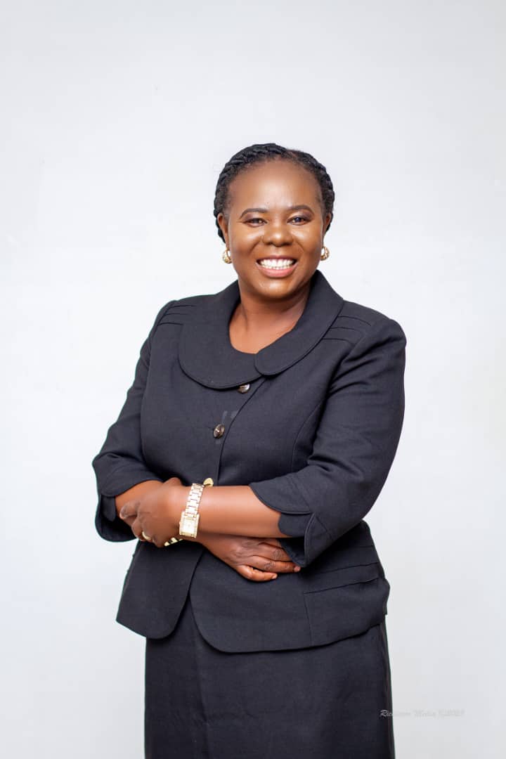 Rev Grace Kasonde, in a dark tailored jacket, photographed against a white background.