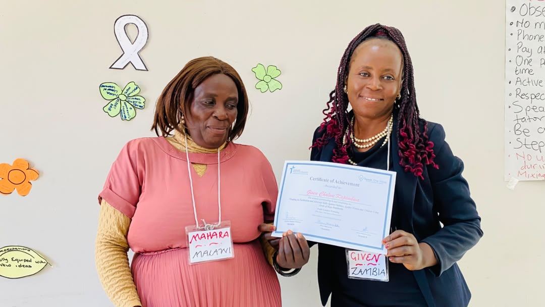A certificate is presented and held up by two participants.