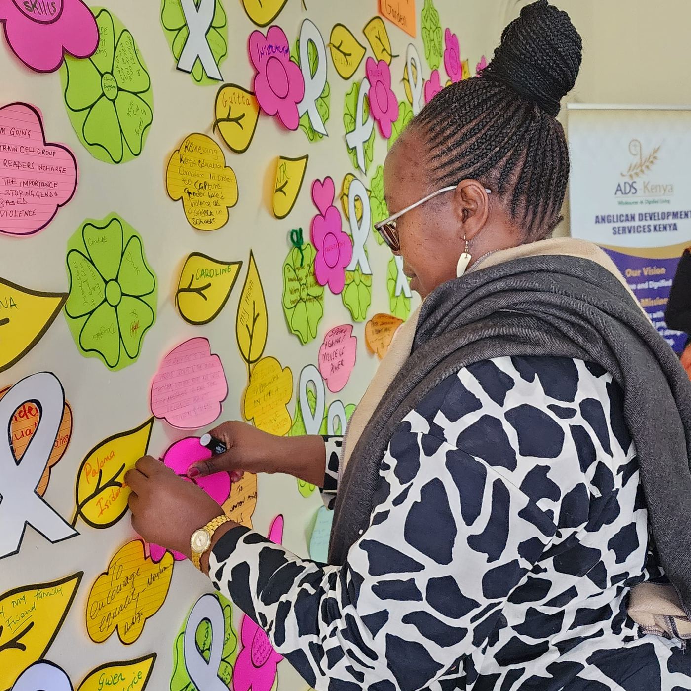 A participant writes on a paper leaf pinned to the wall of expectations.
